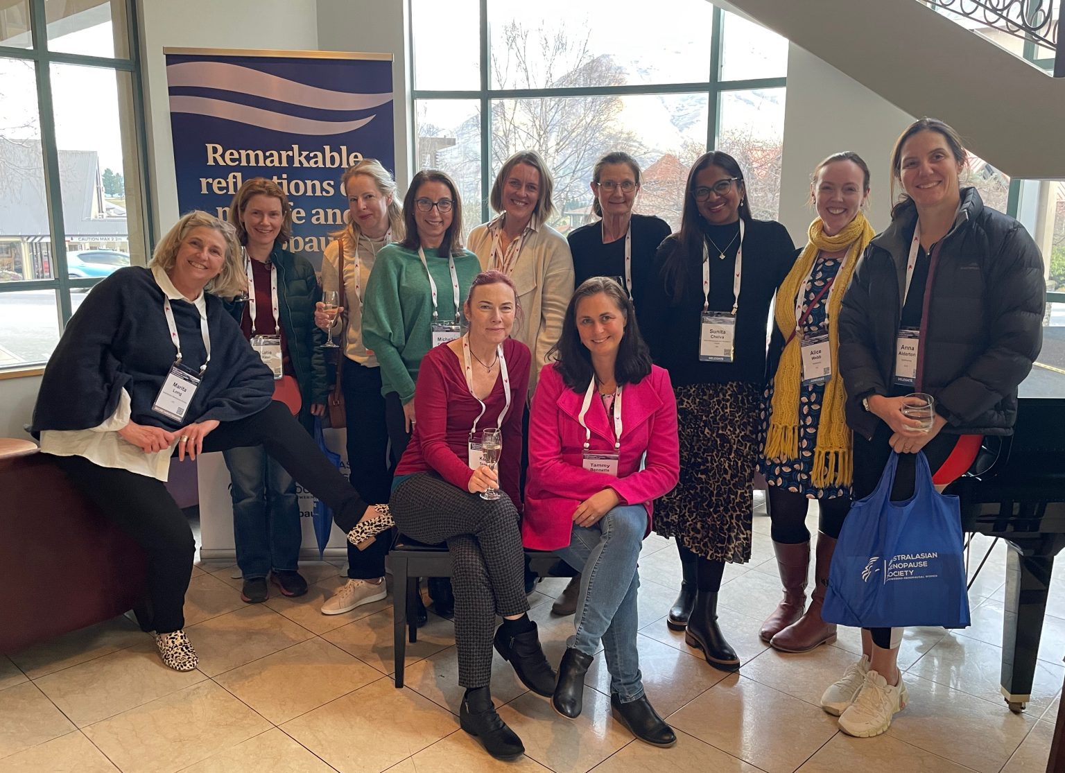 Group of women wearing conference lanyards posing together at the 2023 AMS Menopause Congress, highlighting event participation and professional collaboration.