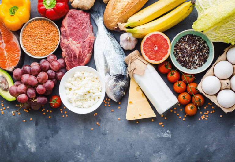 Selection of fresh foods including fish, lean meat, eggs, lentils, fruit, vegetables and dairy, illustrating balanced nutrition during menopause.