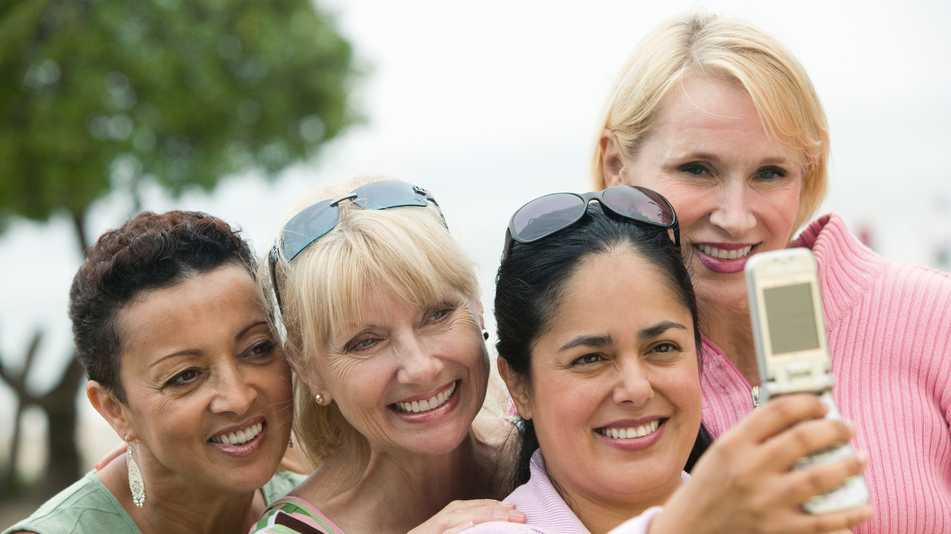 Group of middle-aged women smiling together while taking a selfie outdoors, representing how menopause is impacting Australian women in everyday life.