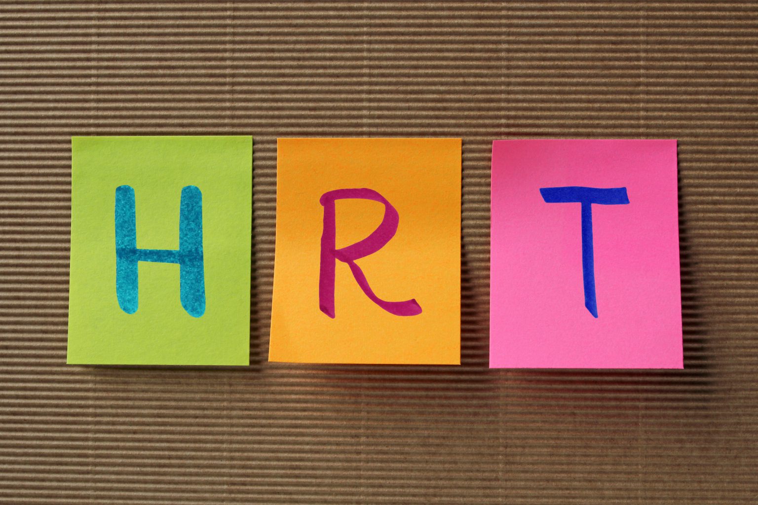 Colourful sticky notes spelling “HRT”, promoting a live-streamed hormone replacement therapy workshop.