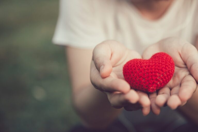 Person holding a small red heart in their hands, symbolising the link between physical activity and better heart health