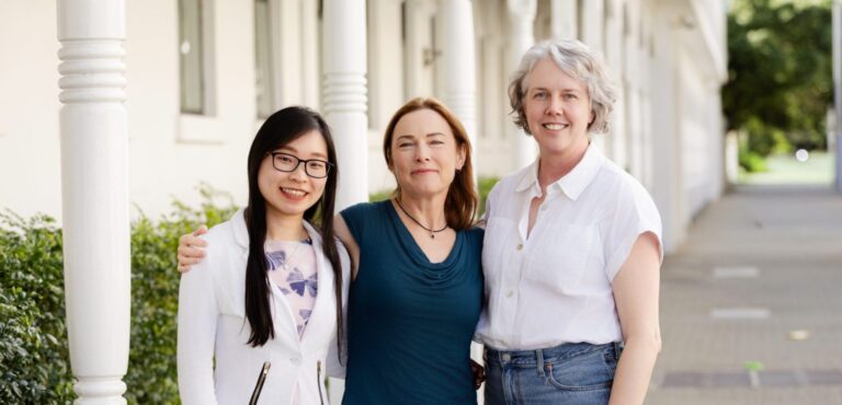 Three women standing together outside a building, representing speakers or attendees at the 2025 Menopause Conference.